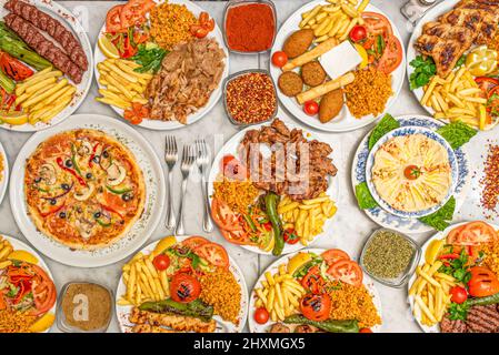 Assiettes de cuisine turque, arabe et méditerranéenne avec poulet frit, falafel, houmous de pois chiches, salade de tomates, croquettes, kebab, côtelettes d'agneau, rouge prêté Banque D'Images