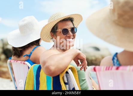 Étaient un groupe de femmes matures qui étendent la confiance aux autres. Photo d'une femme mûre assise et profitez d'une journée sur la plage avec des amis. Banque D'Images