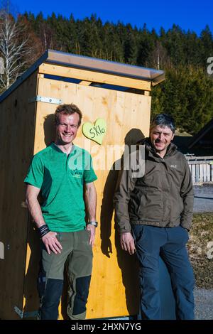 Titisee Neustadt, Allemagne. 10th mars 2022. Fridolin Einwald (l) et son partenaire d'affaires Michael Heizmann se tiennent devant une toilette mobile sèche ou des toilettes à compostage. Les deux entrepreneurs construisent eux-mêmes les toilettes sèches et exploitent un service de location. La Journée de l'eau vise à attirer l'attention sur la pénurie croissante d'eau et la baisse de la qualité de l'eau potable. Credit: Philipp von Ditfurth/dpa/Alay Live News Banque D'Images