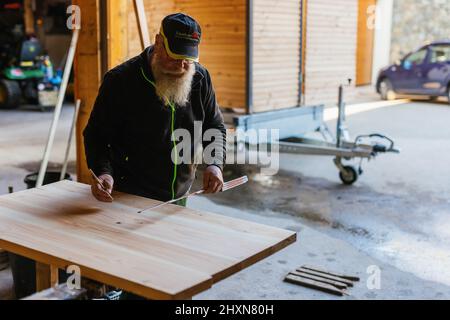 Titisee Neustadt, Allemagne. 10th mars 2022. Ralf Grünsteidl fait une marque avant de scier une planche. Fridolin Einwald et son partenaire d'affaires Michael Heizmann construisent eux-mêmes les toilettes sèches et exploitent un service de location. La Journée de l'eau vise à attirer l'attention sur la pénurie croissante d'eau et la baisse de la qualité de l'eau potable. Credit: Philipp von Ditfurth/dpa/Alay Live News Banque D'Images