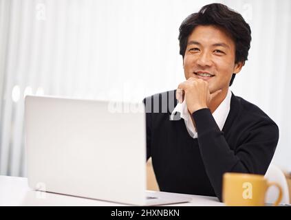 Je me sens bien aujourd'hui. Portrait d'un beau homme d'affaires asiatique travaillant à son bureau. Banque D'Images