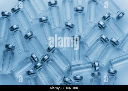 Flacon en ampoule médicale en verre pour injection. La médecine est le chlorure de sodium liquide avec de la solution aqueuse dans l'ampulla. Gros plan. Bouteilles ampoule multicolore sur la couleur de fond et l'eau. Plasma humain. Banque D'Images