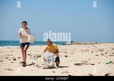 Équipe de bénévoles qui ramassent des bouteilles en plastique et d'autres déchets sur la plage pour empêcher les ordures de retourner dans l'océan Banque D'Images