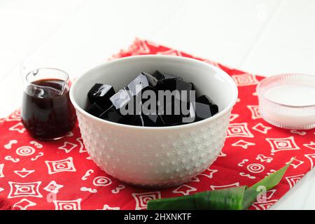 Gelée d'herbe noire coupée en dés (Cinlau Hitam), dessert indonésien à base de feuilles de Cinlau, mangez généralement avec du lait de coco et du sirop de sucre de palme. Populaire pour Tak Banque D'Images