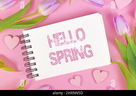 Fleurs de tulipe violet et ornements de coeur entourant le texte 'Hello Spring' Banque D'Images