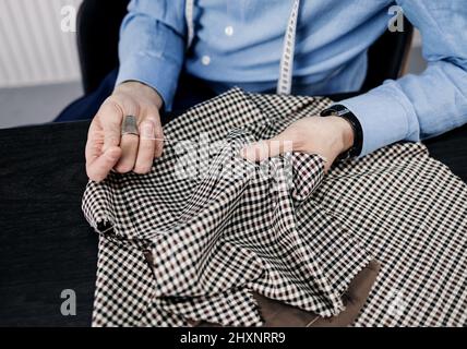 Gros plan vue partielle de l'homme coudre le tissu avec aiguille et le fil avec le tambour Banque D'Images