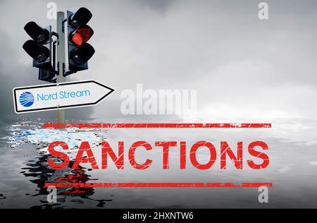 Image symbolique Nord Stream sanctions: Feu de circulation avec signalisation routière et ciel gris réfléchi dans la mer Banque D'Images