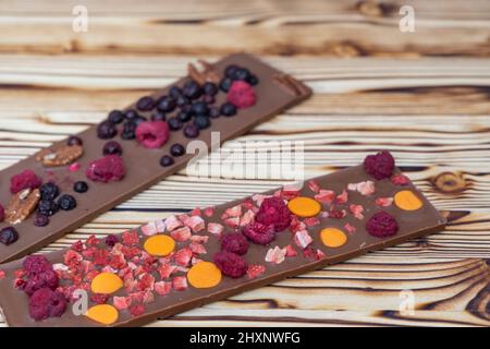 différents types de chocolat avec fruits séchés sur une planche en bois Banque D'Images