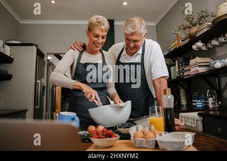 un couple de personnes âgées du caucase cuisant ensemble dans la cuisine Banque D'Images