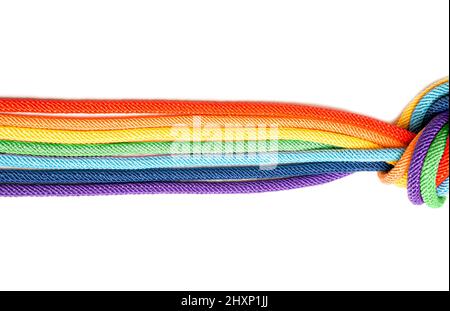 Sept fils de coton tressé teints en arc-en-ciel noués ensemble isolés sur fond blanc. Concept de concentrateur créatif. Banque D'Images