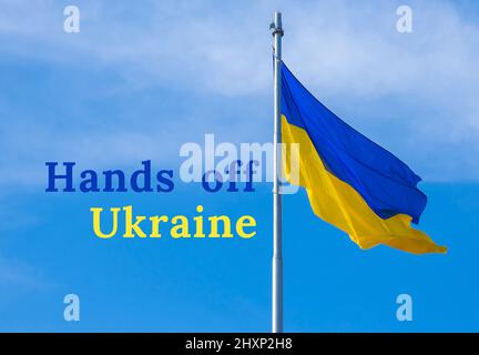 LE TEXTE de L'UKRAINE sur le drapeau national ukrainien flotte dans le vent contre le ciel bleu. Symbole national du peuple ukrainien - bleu et jaune. Po Banque D'Images