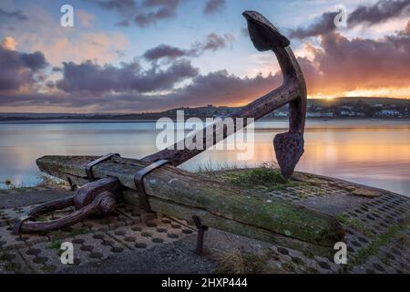 Appledore, North Devon, Angleterre. Lundi 14th mars 2022. Le soleil se lève derrière le point de repère Anchor sur le quai dans le village côtier d'Appledore. Une journée d'intervalles ensoleillés et de vents légers est prévue pour le North Devon. Crédit : Terry Mathews/Alay Live News Banque D'Images