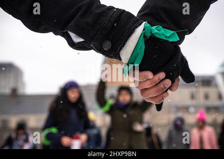 Toronto, Canada. 13th mars 2022. Les manifestants ont vu se tenir les mains pendant le rassemblement des femmes « Live with No Fear ». Les femmes organisent une marche féministe pour exiger la justice et faire de la violence visible contre les femmes latino-américaines devant l'hôtel de ville de Toronto. Crédit : SOPA Images Limited/Alamy Live News Banque D'Images