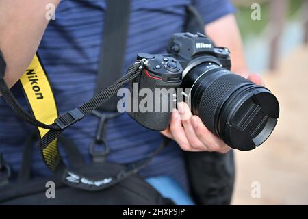 Hommes tenant Nikon Z9 sans miroir. Un jeune homme qui fait une séance photo. Banque D'Images