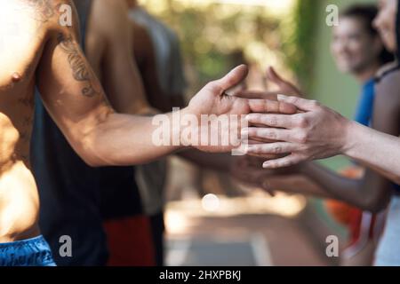 Pratiquer un esprit sportif de qualité. Photo courte d'équipes de basket-ball masculines et féminines en contact avec les mains sur le terrain après un bon match. Banque D'Images