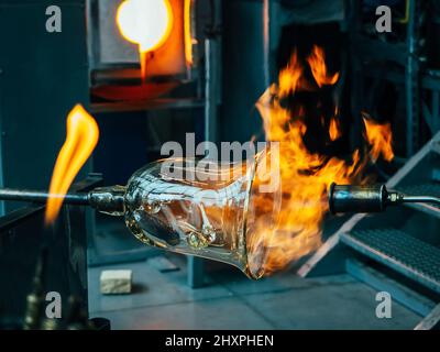 Création d'art traditionnel en verre avec torche chaude et tuyau de soufflage de verre. Créer le bol en verre lourd par méthode traditionnelle Banque D'Images