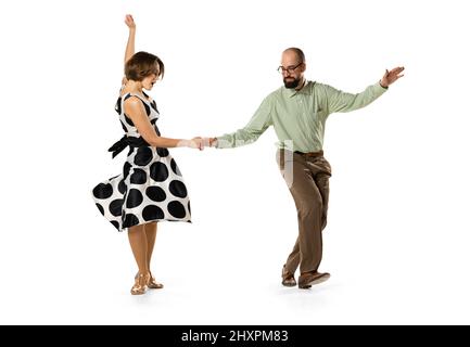 Portrait dynamique de deux danseurs dans des tenues rétro vintage dansant la danse du houblon de lindy isolée sur fond blanc. Concept de l'art, de l'action Banque D'Images