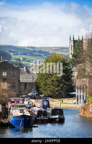 Sowerby Bridge, West Yorkshire, Royaume-Uni. 14th mars 2022. Météo au Royaume-Uni. Un beau ciel bleu et une journée ensoleillée au bassin historique du pont Sowerby, sur le canal Calder & Hebble/Rochdale, qui offre des amarres et des services de chantier agréables et sécurisés à l'ombre de la tour Wainhouse classée en Grade2. Le port de plaisance a été utilisé comme un emplacement pour divers dramatiques de télévision, y compris le thriller Sarah Lancashire "Happy Valley". Crédit : Windmill Images/Alamy Live News Banque D'Images