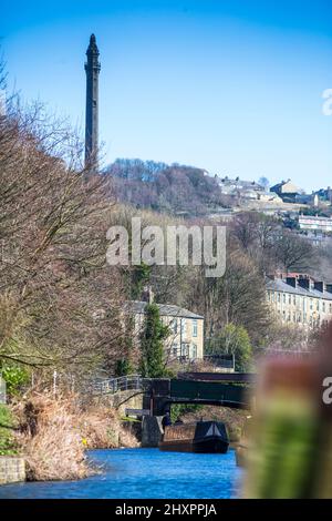 Sowerby Bridge, West Yorkshire, Royaume-Uni. 14th mars 2022. Météo au Royaume-Uni. Un beau ciel bleu et une journée ensoleillée au bassin historique du pont Sowerby, sur le canal Calder & Hebble/Rochdale, qui offre des amarres et des services de chantier agréables et sécurisés à l'ombre de la tour Wainhouse classée en Grade2. Le port de plaisance a été utilisé comme un emplacement pour divers dramatiques de télévision, y compris le thriller Sarah Lancashire "Happy Valley". Crédit : Windmill Images/Alamy Live News Banque D'Images