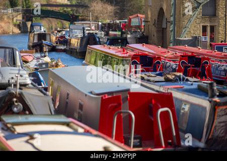 Sowerby Bridge, West Yorkshire, Royaume-Uni. 14th mars 2022. Météo au Royaume-Uni. Un beau ciel bleu et une journée ensoleillée au bassin historique du pont Sowerby, sur le canal Calder & Hebble/Rochdale, qui offre des amarres et des services de chantier agréables et sécurisés à l'ombre de la tour Wainhouse classée en Grade2. Le port de plaisance a été utilisé comme un emplacement pour divers dramatiques de télévision, y compris le thriller Sarah Lancashire "Happy Valley". Crédit : Windmill Images/Alamy Live News Banque D'Images