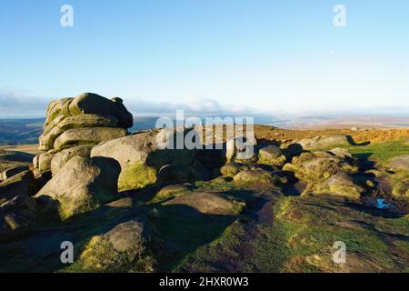 Matin d'automne brumeux parmi les formations rocheuses de pierre à aiguiser altérées de Derbyshires Higger Tor. Banque D'Images