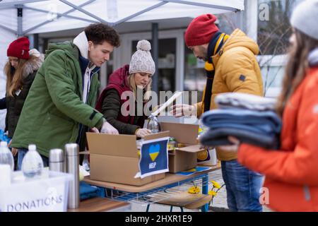 Volontaires distribuant des dontaions aux réfugiés à la frontière ukrainienne, concept de guerre russo-ukrainien. Banque D'Images