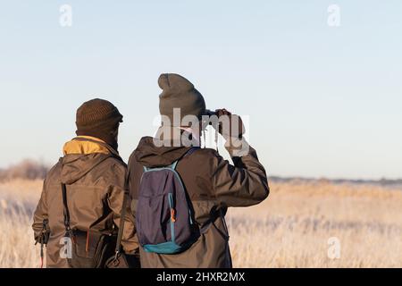 Deux hommes sur leur dos observant les oiseaux. Banque D'Images