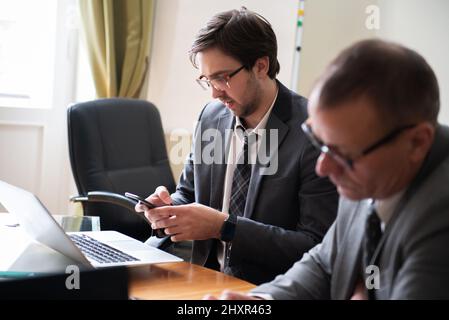 Les professionnels parlent et utilisent des ordinateurs portables et des tablettes. Banque D'Images