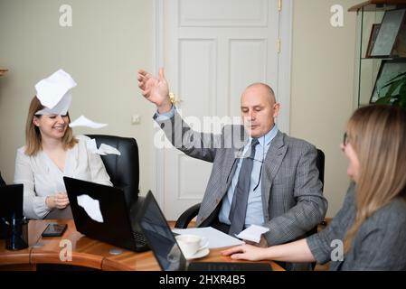 Homme d'affaires senior assis à la table ronde et document déchirable Banque D'Images