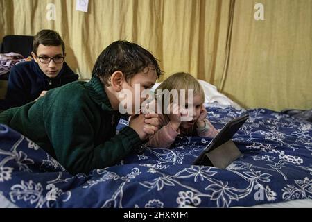 Lviv, Ukraine. 13th mars 2022. Des enfants regardent des dessins animés dans un abri, à Lviv, au milieu de l'invasion de la Russie. (Photo par Alex Chan TSZ Yuk/SOPA Images/Sipa USA) crédit: SIPA USA/Alay Live News Banque D'Images