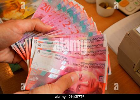 Femme compte les billets de banque en devise suisse Banque D'Images