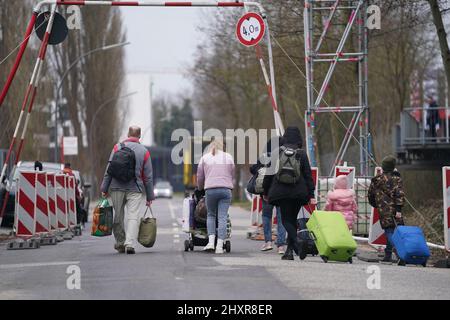 Hambourg, Allemagne. 14th mars 2022. Les réfugiés ukrainiens quittent avec leurs bagages le refuge de réfugiés dans l'ancien marché de gros de Fegro, dans le district de Harburg. Credit: Marcus Brandt/dpa/Alay Live News Banque D'Images