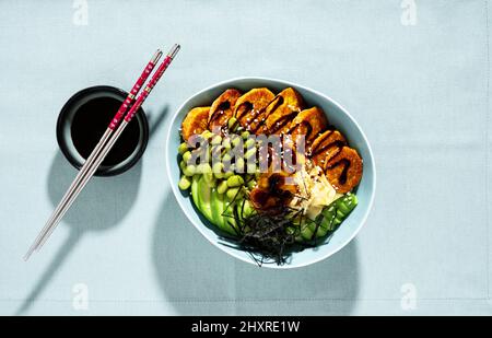 bol à sushi végétalien avec patate douce cuite au four, haricots édamames, avocat et sauce au jus. alternative saine Banque D'Images