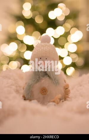 Figurine bonhomme de neige avec lumières bokeh en arrière-plan Banque D'Images