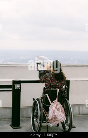 Jeune femme en fauteuil roulant utilisant le viseur à Los angeles Banque D'Images