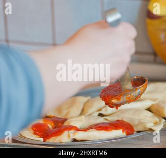 la sauce à la viande est versée avec une louche sur les pâtes fraîchement cuites Banque D'Images