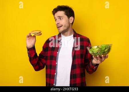 Portrait de drôle Guy tenant Burger et salade Banque D'Images