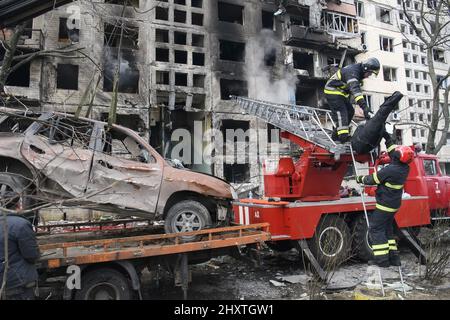 Kiev, Ukraine. 14th mars 2022. Des pompiers travaillent pour nettoyer les gravats et éteindre un incendie près d'un bâtiment qui a été lourdement endommagé par une fusée russe dans le cadre de l'invasion de l'Ukraine par la Russie dans le district d'Obolon près de Kiev, Ukraine, le lundi 14 mars 2022. Photo de Vladyslav Musiienko/UPI crédit: UPI/Alay Live News Banque D'Images