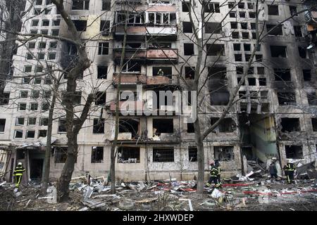 Kiev, Ukraine. 14th mars 2022. Des pompiers travaillent pour nettoyer les gravats et éteindre un incendie près d'un bâtiment qui a été lourdement endommagé par une fusée russe dans le cadre de l'invasion de l'Ukraine par la Russie dans le district d'Obolon près de Kiev, Ukraine, le lundi 14 mars 2022. Photo de Vladyslav Musiienko/UPI crédit: UPI/Alay Live News Banque D'Images