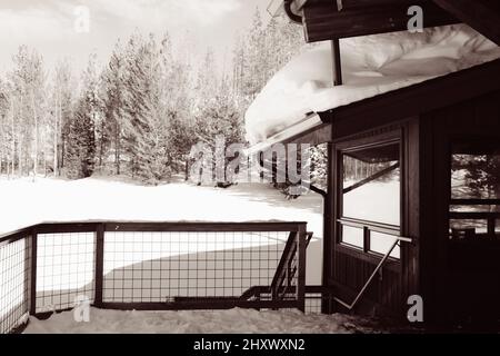 Bâtiment en bois avec un toit enneigé dans une zone rurale en hiver Banque D'Images