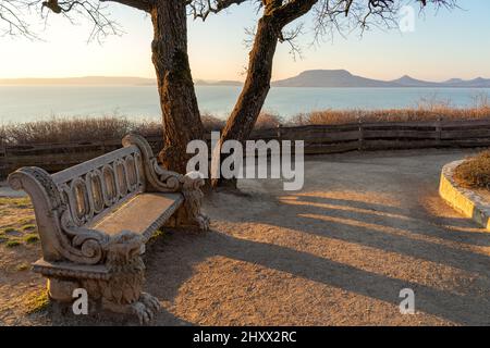 Beau lac balaton paysage à Fonyod Hongrie avec banc de pierre décoré et la colline de badacsony sur le fond. Banque D'Images