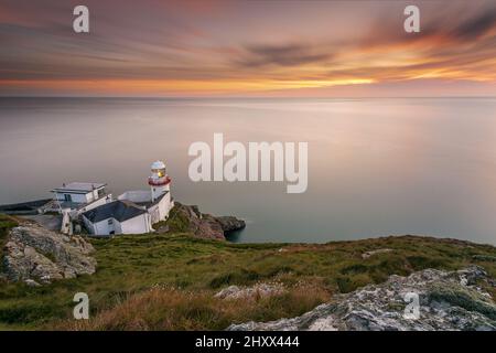 Magnifique vue aérienne du phare de Wicklow Head avec un ciel de coucher de soleil en République d'Irlande Banque D'Images