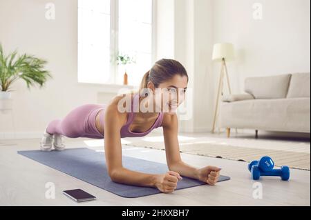 FIT jeune femme faisant un exercice de planche d'avant-bras pendant son  entraînement de fitness à la maison Photo Stock - Alamy
