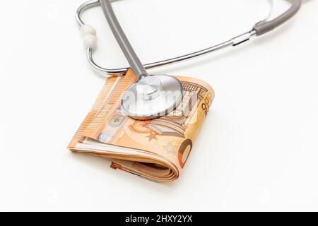 Coût des soins de santé. Stéthoscope médical sur pile de billets Euro isolé sur blanc, gros plan. Budget de la sécurité sociale en Europe Banque D'Images