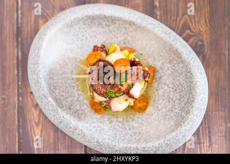 Photo d'une assiette de pierre avec des légumes et des calmars frits Banque D'Images