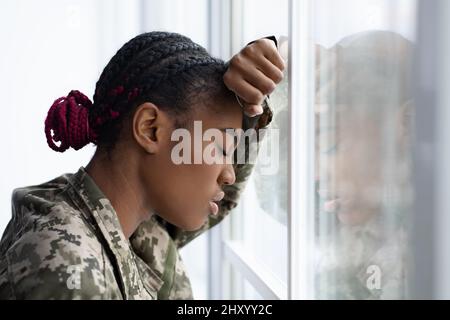 Concept de dépression. Gros plan de la femme militaire noire en colère penchée à la fenêtre Banque D'Images