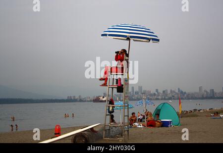 Maître nageur assis sous un parapluie à Kitsilano Beach, Vancouver, Canada Banque D'Images