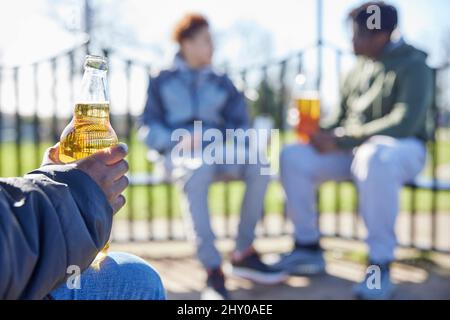 Gros plan sur les adolescents mineurs qui consomment de l'alcool à Park Banque D'Images