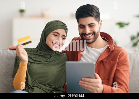 Couple du Moyen-Orient magasiner en ligne à l'aide d'une tablette numérique à la maison Banque D'Images