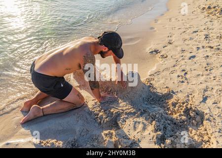 Playa Balandra, la Paz, Baja California sur, Mexique. 11 novembre 2021. Homme construisant des sculptures de sable sur la plage de Balandra. Banque D'Images